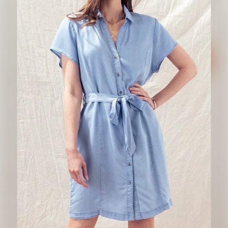 "Elevate your casual wardrobe with this stylish Denim Tunic Dress. Featuring cap short sleeves and a button-up design, this shirt dress is made from soft Tencel fabric for ultimate comfort. A collared neckline and string waist belt add the perfect finishing touches to this versatile piece. Available in denim blue and mint sage, this collared jean dress is perfect for any occasion, from a relaxing vacation to a Sunday brunch, church or everyday casual outing. Sizes range from Small to Large, making it easy to find your perfect fit. Small (US 2), Medium (4-6), Large (6-8) Model is Wearing Size Small Model: 5'9\"  32C bust, 25\" waist, and 36\" hips Color may vary slightly due to monitor resolution  100% Tencel NO REFUNDS-please check sizing Perfect, Soft Cozy top to wear with your Dainty Acc Chambray Short Sleeve Dress With Pockets, Short Sleeve Chambray Dresses With Pockets, Summer Chambray Button-up Shirt Dress, Denim Blue Short Sleeve Shirt Dress, Chambray Shirt Dress For Summer, Summer Chambray Shirt Dress, Denim Blue Chambray Short Sleeve Dress, Fitted Chambray Denim Dress With Short Sleeves, Short Sleeve Denim Dress For Work