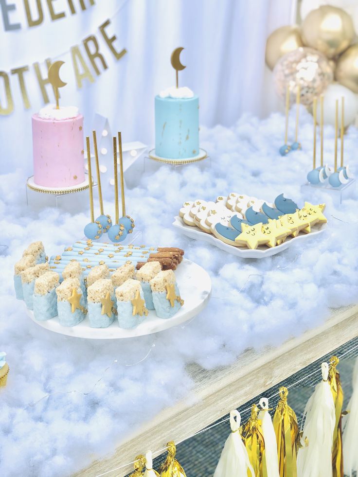 a table filled with cakes and desserts on top of clouds