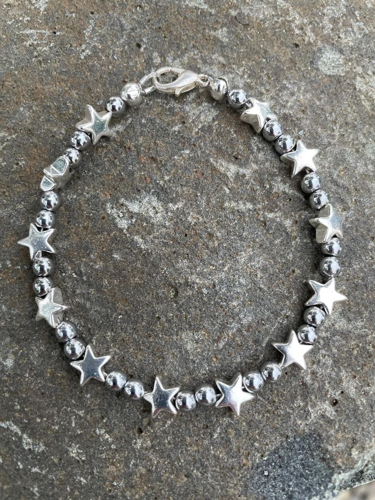 Handcrafted tarnish resistant bracelet with silver hematite stars and 4mm hematite round beads. Lobster claw clasp fastens to your wrist securely. Silver Beaded Bracelet With Star Charm And Round Beads, Silver Beaded Bracelets With Star Charm, Silver Magnetic Beaded Bracelets With Round Beads, Silver Beaded Bracelets With Magnetic Round Beads, Silver Beaded Bracelets, Rye Beach, Silver Bead Bracelet, Star Bracelet, Sterling Silver Bracelet