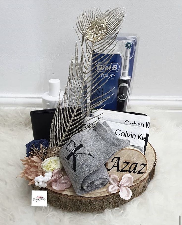 an assortment of personal care products displayed on a wooden slice with feathers and flowers in the foreground