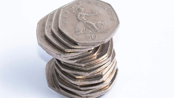 a stack of silver coins sitting next to each other on top of a white surface