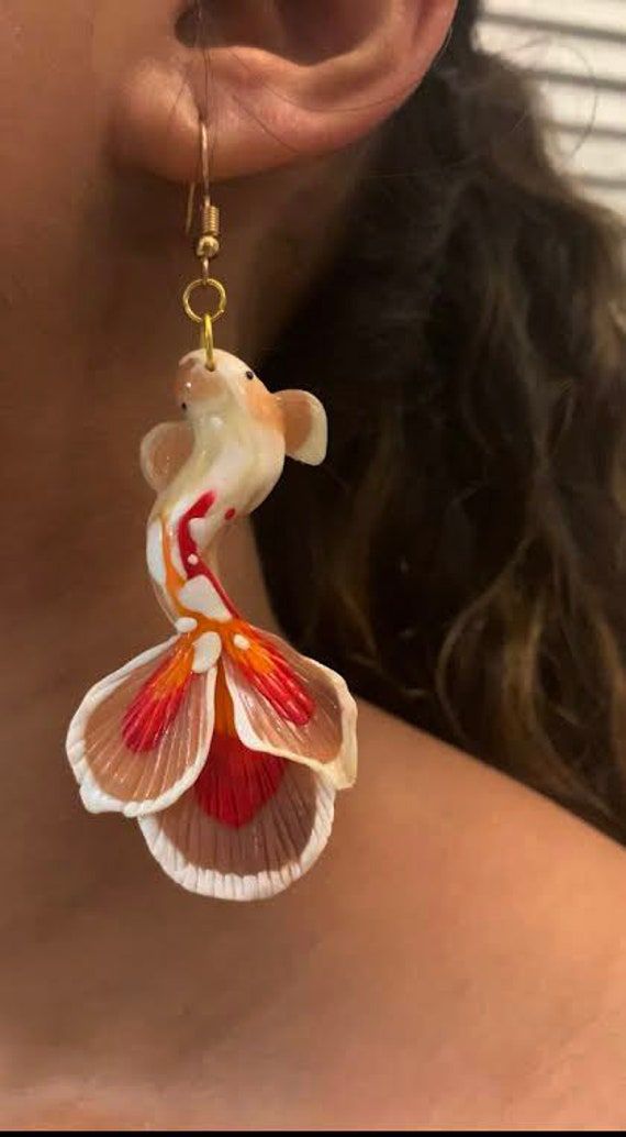 Whimsical koi fish earring made of polymer clay.  Inspired by the Kohaku koi fish Glow in the dark Lightweight and durable,  Weighs  0.2 oz each. Handmade Fish-shaped Earrings For Gifts, Red Fish-shaped Jewelry Gift, Handmade White Fish-shaped Jewelry, Weird Jewelry, Geniale Tattoos, Dope Jewelry, Funky Jewelry, Jewelry Lookbook, Fantasy Jewelry