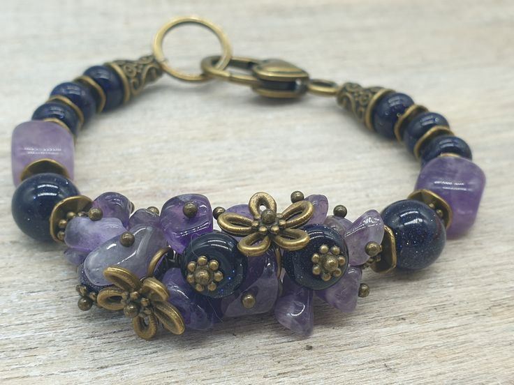 "ELFs Handmade Boho Summer Vintage Victorian style Attractive Blue Goldstone and Amethyst natural gemstone bracelet with antique bronze textured findings and large decorative clasp. Total length 7.5\"/19cm Comes in velvet jewellery pouch. Blue Goldstone is a man-made stone. Its sparkle comes from flecks of copper. In crystal healing it is said to be the stone of confidence and ambition, encouraging motivation and drive. It has a positive attitude; it is an uplifting stone. Amethyst is a natural Healing Brass Jewelry With Natural Stones, Bohemian Jewelry With Gemstone Accents, Bohemian Brass Bracelets With Natural Stones, Handmade Spiritual Bronze Beaded Bracelets, Healing Brass Jewelry With Gemstone Beads, Spiritual Handmade Bronze Beaded Bracelets, Bohemian Amethyst Beaded Bracelets Handmade, Handmade Amethyst Beaded Bracelets In Bohemian Style, Healing Bronze Gemstone Beads Jewelry