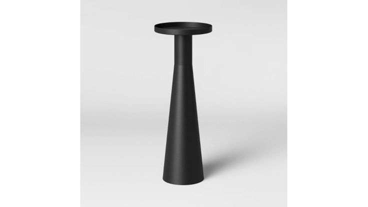 a tall black vase sitting on top of a table