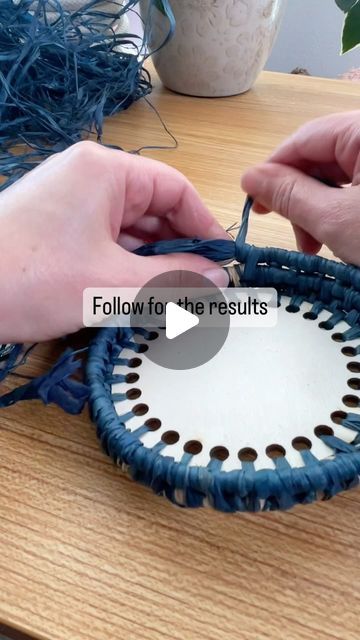 two hands are working on a woven basket