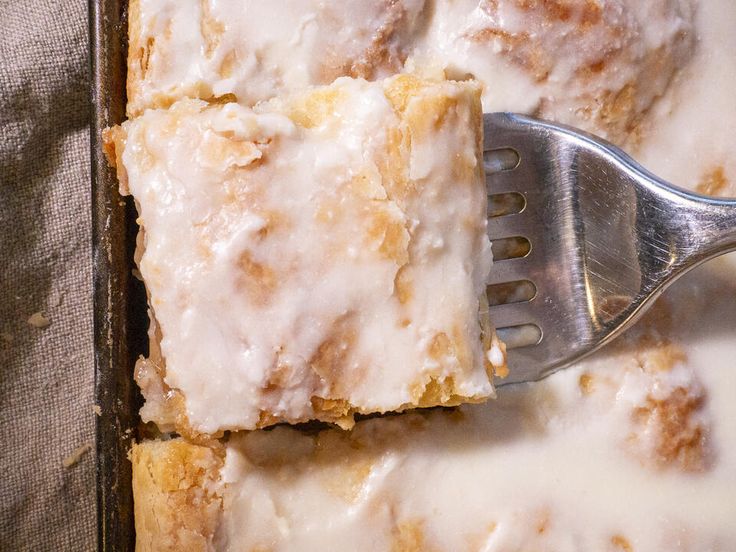 a close up of a piece of cake on a pan with a fork in it