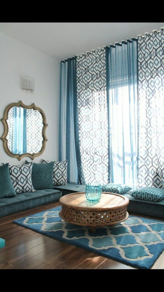 a living room filled with furniture and blue curtains