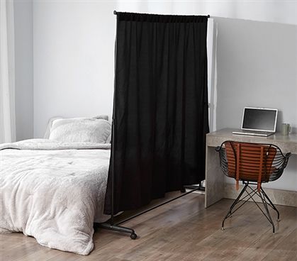 a bed sitting in a bedroom next to a desk with a laptop on top of it