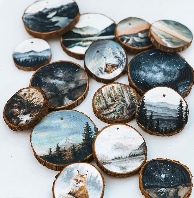 wood slices decorated with pictures of mountains and trees