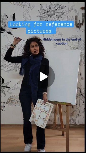 a woman standing in front of a white board with writing on it and holding a paintbrush