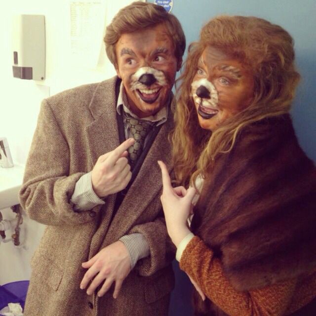 two people dressed up in costumes standing next to each other with fake animals on their faces