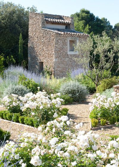 an old stone house surrounded by white flowers