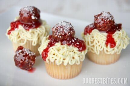 three cupcakes with white frosting and red toppings on top are shown