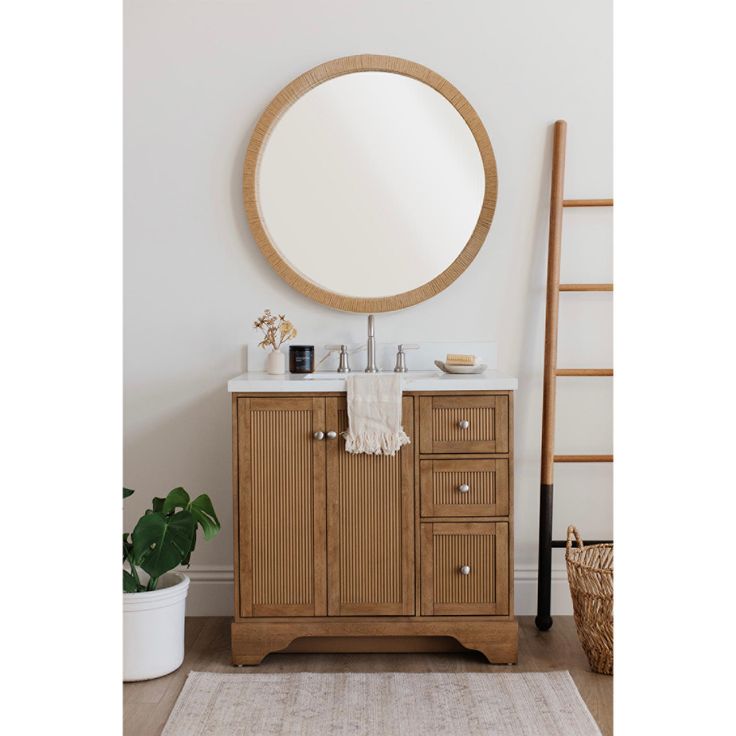 a bathroom vanity with a round mirror above it