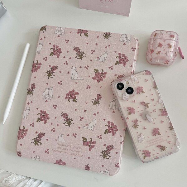 an ipad case sitting on top of a white table next to a pink flowered notebook