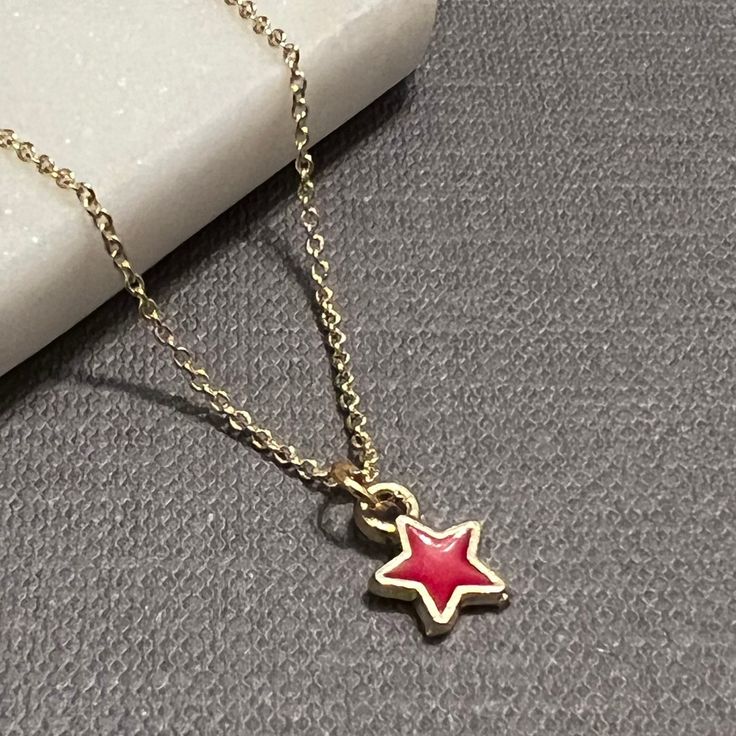 "A tiny enamel star charm hangs gently from a dainty gold vermeil chain...simple and elegant, perfect for layering. The star charm is available in red, yellow, white, light blue, dark blue, or light pink. The chain is 16\" with a 2\" extender. Very delicate and beautiful! 💙 If you prefer a magnetic clasp, check out the add-ons and upgrades section of our shop - it's available as an add-on to any bracelet and most necklaces, along with the option to upgrade your accent metal to solid 14k gold, y Star Gold Jewelry, Dainty Star-shaped Charm Necklace, Cute Gold Star Jewelry, Enamel Star Charm Jewelry, Gold Star Charm Necklace Handmade, Handmade Gold Star Charm Necklaces, Handmade Gold Charm Necklaces With Star Shape, Handmade Gold Star Charm Necklace, Red Necklace With Star Charm As Gift