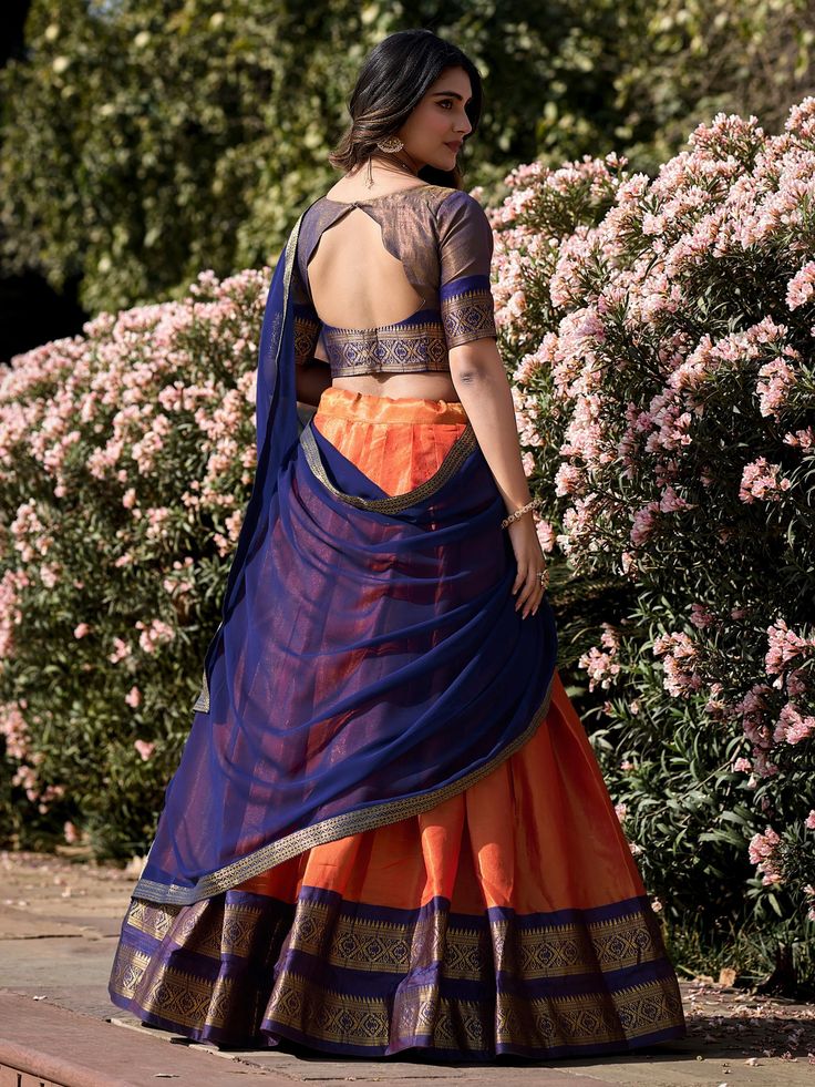 Embrace the vibrant elegance of our orange Kanchipuram silk lehenga, exquisitely paired with a blue Kanchipuram silk choli and a matching blue georgette dupatta. This ensemble showcases the rich heritage and craftsmanship of traditional Indian attire, featuring intricate zari weaving work that exudes luxury and sophistication. The orange lehenga, with its striking color and detailed design, is the perfect choice for making a bold statement at any grand event.
The lehenga offers a generous 3.70-m Beautiful Half Sarees, Kanchipuram Blouse Designs Back, Blouse Back Neck Designs For Half Saree Latest, Checked Saree Silk, Blouse For Half Saree Designs, Lehenga Design From Saree, Pattu Saree Into Lehenga, Back Open Neck Designs For Blouses, Half Saree Lehenga Draping