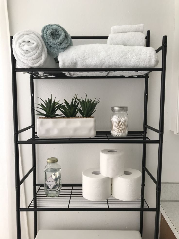 a bathroom shelf with toilet paper and towels