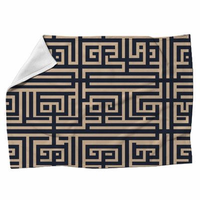 a black and beige blanket with an intricate design on it's side, in the middle