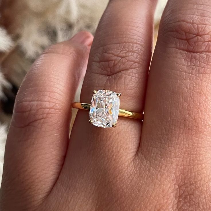 a woman's hand with a ring on it and a diamond in the middle