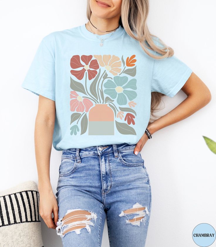 🌼Discover our Retro Boho Floral Comfort Colors shirt!🌼 This trendy Colorful Flower t-shirt features an eye-catching boho graphic design that is sure to enhance your outfit! Made of 100% ring-spun ethically grown cotton, this shirt is super soft and comfortable. It has a relaxed fit which is made of a medium fabric that is preshrunk. Looks super cute with shorts, jeans or as an oversized beach cover up. Great gift idea for a Boho Lover! Comes in 12 pretty colors! ♦️Please let me know if you do not see the color shirt you would like.♦️ 💠PRINT: This is a handmade, Direct-to-Garment printed item. The designs are professionally printed directly on to the shirt. All over printing is used. The ink is printed directly into the fabric. ✦Images may sometimes appear larger in the photo than in per Retro Blue Printed T-shirt, Casual Light Blue Printed T-shirt, Light Blue Graphic Tee For Spring, Trendy Crew Neck Shirt With Plant Print, Trendy Light Blue T-shirt For Spring, Blue T-shirt With Funny Print For Spring, Printed Light Blue Short Sleeve T-shirt, Multicolor Crew Neck T-shirt With Plant Print, Blue Short Sleeve Tops With Plant Print