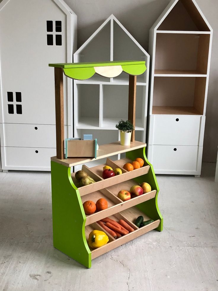 an assortment of fruits and vegetables on display in a children's playroom area