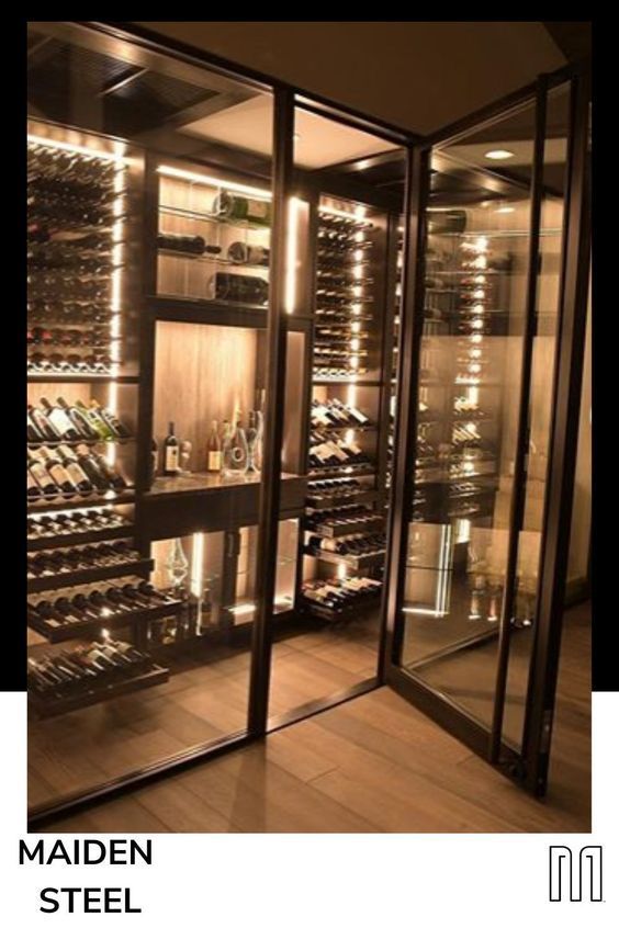 the inside of a wine cellar with many bottles and glasses on display in glass doors