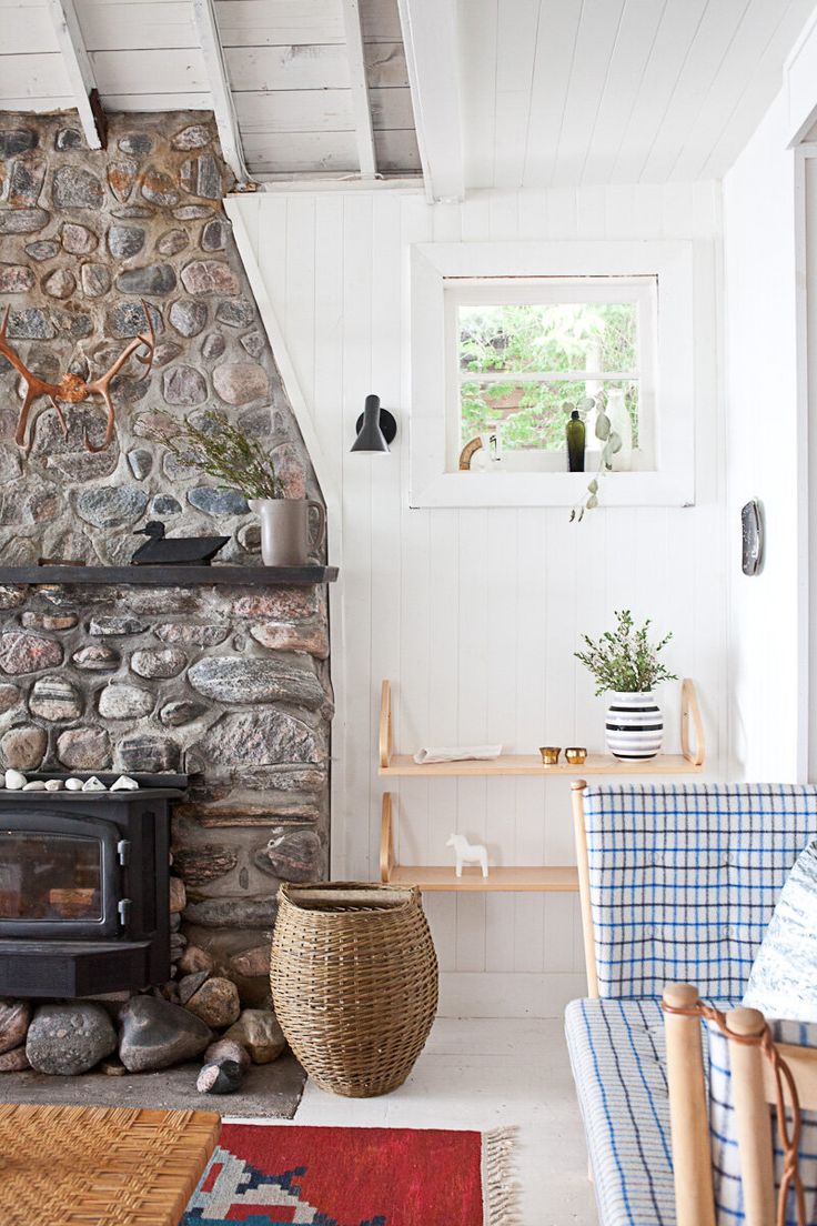 a living room filled with furniture and a fire place in front of a stone wall