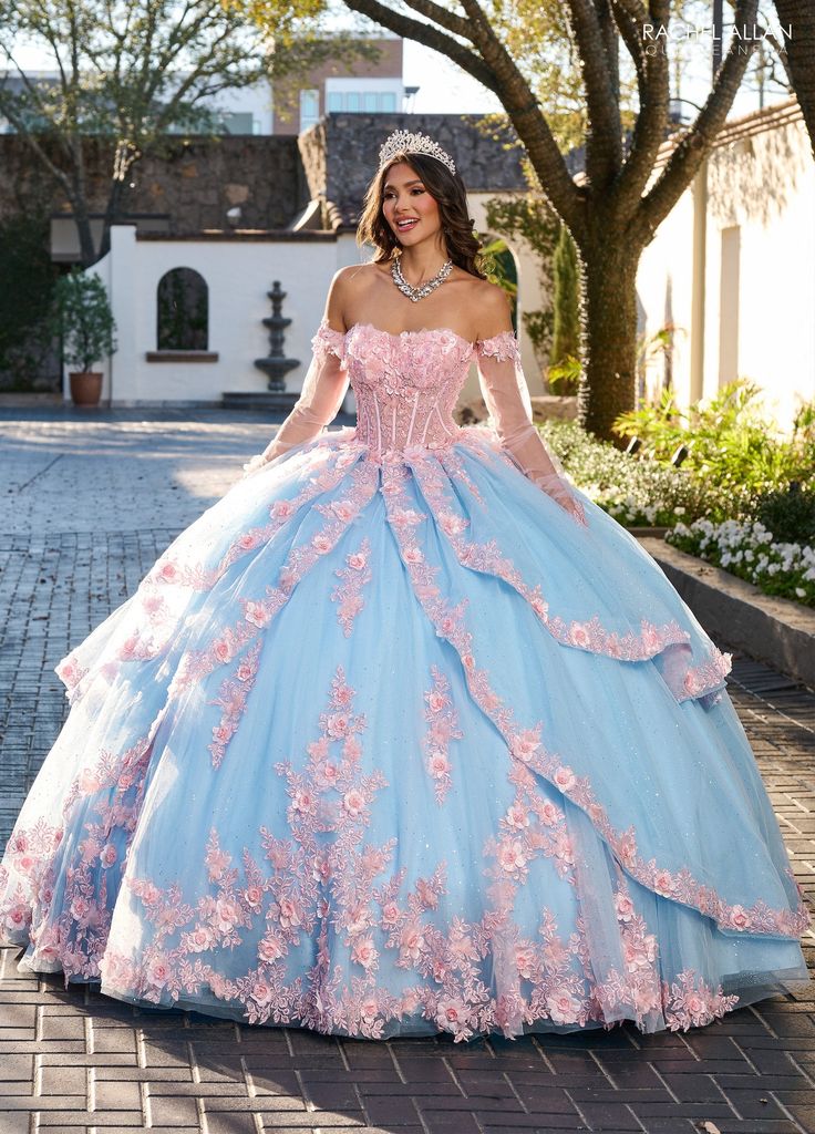 Sparkle from every angle in this floral applique long strapless long-sleeve dress with A-line skirt by Rachel Allan RQ2196. Your princess gown awaits which is the essence of dreamy elegance. The gown features a sweetheart neckline with off-the-shoulder sleeves that add a romantic and youthful touch. The bodice is intricately adorned with floral appliqués and shimmering beadwork that continue throughout the voluminous tulle skirt, creating a cohesive and enchanting design. Layers of soft tulle ca Long Sleeve Ball Gown With Fitted Bodice For Quinceanera, Long Sleeve Fitted Bodice Ball Gown For Quinceanera, Dream Quinceanera, Quinceanera Themes Dresses, Quinceñera Dresses, Quinceanera Dresses Pink, Quinceanera Dresses Blue, Princess Prom Dresses, Military Ball Dresses