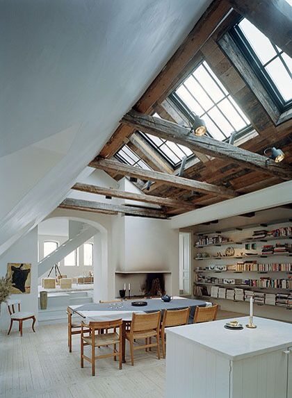 an open kitchen and dining room with skylights above the stovetop, in a loft style home