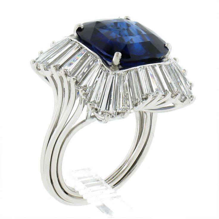 a ring with a large blue stone surrounded by baguettes and diamonds on it