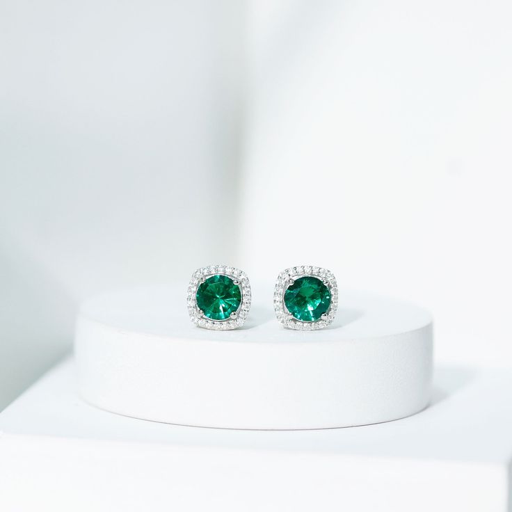 Product Details Experience the enchantment of these captivating Stud Earrings, showcasing a Round Shape Lab Created Emerald at the center, delicately held in a Prong Setting. Surrounding the vibrant created emerald is a dazzling Halo of Moissanite gemstones, adding an extra touch of sparkle. With the inclusion of a Screw Back Closure, these halo earrings ensure a secure fit, providing peace of mind. Whether for a special occasion or everyday wear, these beautiful earrings are guaranteed to elici Elegant Green Halo Jewelry, Elegant Green Jewelry With Halo, Elegant Green Jewelry With Halo Design, Anniversary Green Diamond Earrings, Green Diamond Earrings With Prong Setting, Gia Certified Green Diamond Earrings For Anniversary, Green Halo Design Fine Jewelry Earrings, Elegant Green Halo Earrings, Green Halo Earrings For Anniversary