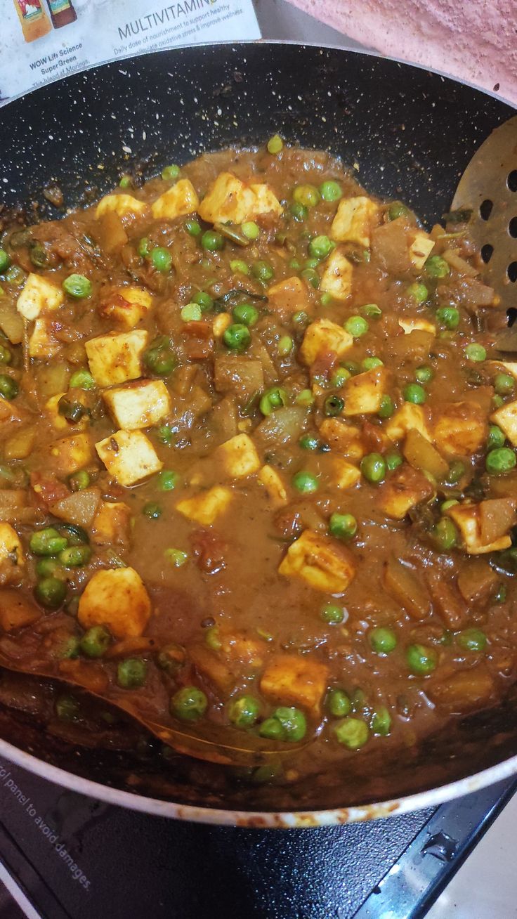 peas and tofu cooking in a pan on the stove