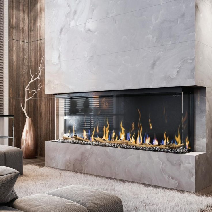 a modern fireplace in the middle of a living room with white furnishing on the floor