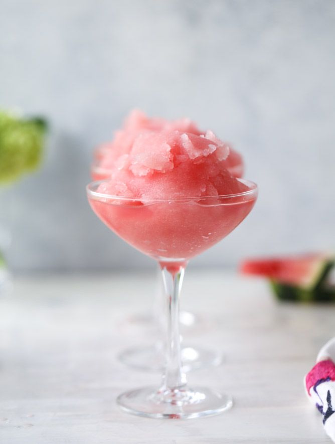 two glasses filled with watermelon sorbet on top of a white table