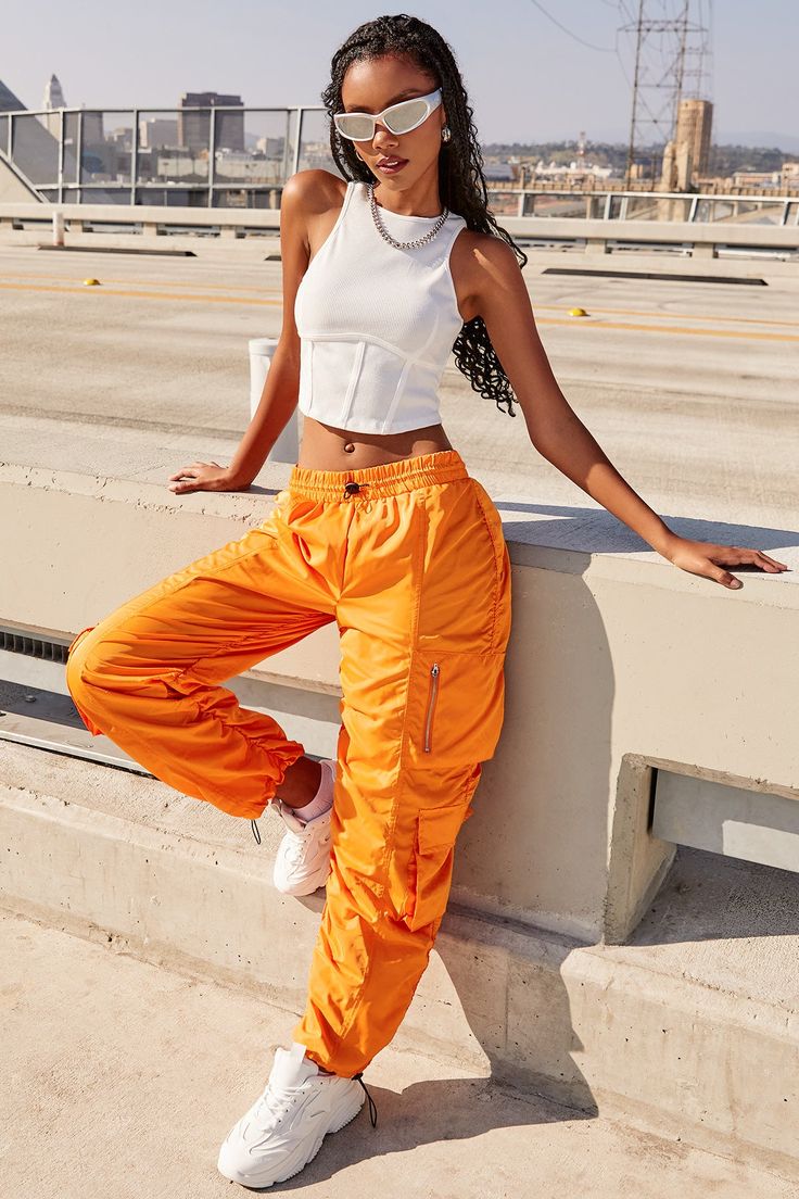 It’s giving off-duty vibes! Our Women's High-Rise Rouched Nylon Jogger is the perfect baggy pant to add to your wardrobe! Designed with an adjustable bungee cord at the elasticized waistband for the perfect fit and comfort. These high waisted pants are meant to be oversized with a baggy and slouchy fit. Featuring silver hardware and large cargo pockets for a sporty-chic vibe. We’ve also added adjustable bungee cords at the bottom hems to give you the option of wearing them more scrunched up at t Hip Hop Cargo Pants, Sporty Fashion, Ymi Jeans, Bungee Cords, Cargo Pants Outfit, Pics Inspo, Orange Outfit, Lights Camera Action, Hip Hop Outfits