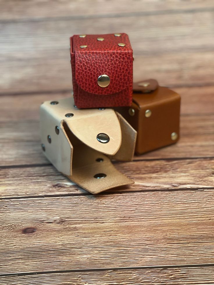 three leather dice holders sitting on top of each other