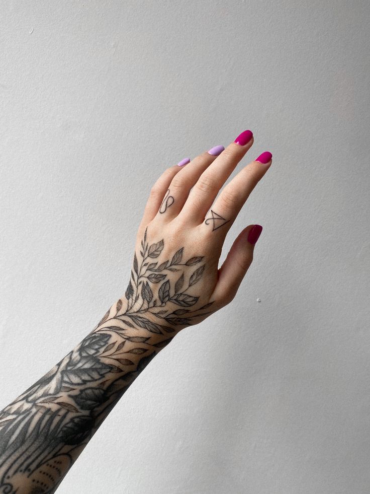 a woman's hand with tattoos on it