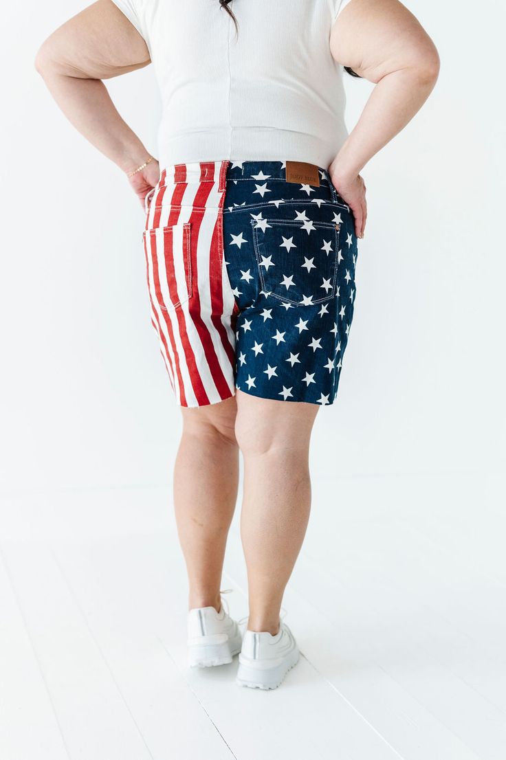 Features High rise Frayed hem Zipper fly Flag print: blue with white stars; red and white stripes 93% Cotton, 6% Polyester, 1% Spandex Size + Fit Kristin is 5'4", a size 1 and is wearing a Small Ashley is 5'6", a size 18 and is wearing a 1X Small 2-4, Medium 6-8, Large 10-12, X-Large 14-16, 1X 16-18, 2X 18-20, 3X 20-22 True to size. Do have stretch, but do not lose shape. Waist measurements are taken while laying flat and doubled. Curvy sizes have more room in the waist Click here for white top Patriotic Stretch Bottoms For 4th Of July, Casual American Flag Bottoms For 4th Of July, Patriotic Fitted Bottoms For 4th Of July, Patriotic American Flag Bottoms For 4th Of July, Red Stretch Bottoms For 4th Of July, Short Length Cotton Bottoms With Flag Print, American Flag Cotton Bottoms For 4th Of July, American Flag Cotton Bottoms For Memorial Day, Cotton American Flag Print Shorts For 4th Of July