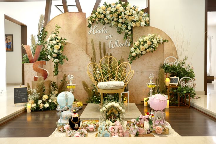 an arrangement of flowers and decorations on display at a wedding ceremony in front of a backdrop