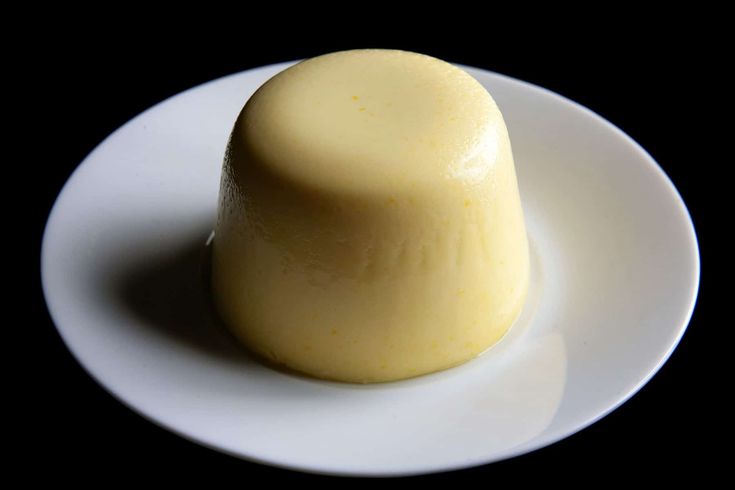 a white plate topped with a piece of cake on top of a black tablecloth