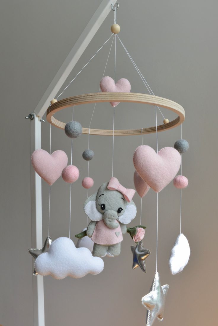 a mobile with hearts, an elephant and a star hanging from it's side