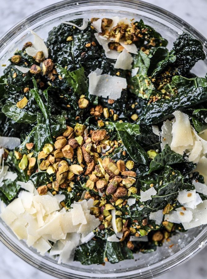 a glass bowl filled with spinach, cheese and other toppings on top of a table