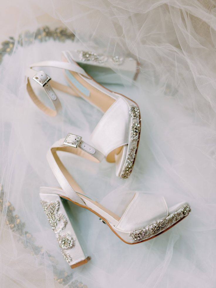 two pairs of white shoes with crystal embellishments