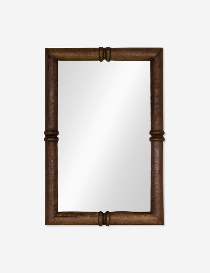 a wooden frame mirror on a white wall with an old fashioned design in the middle