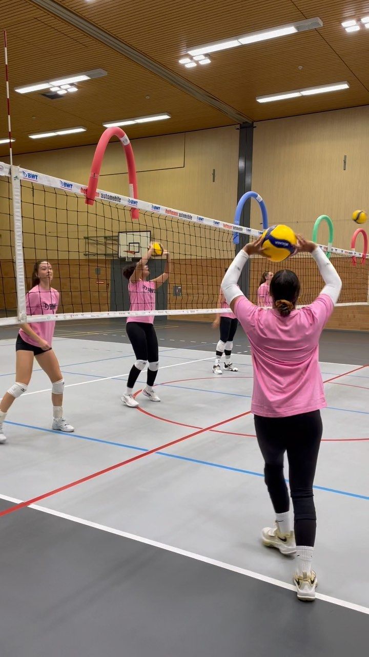 some girls are playing volleyball on a court with their rackets and balls in the air