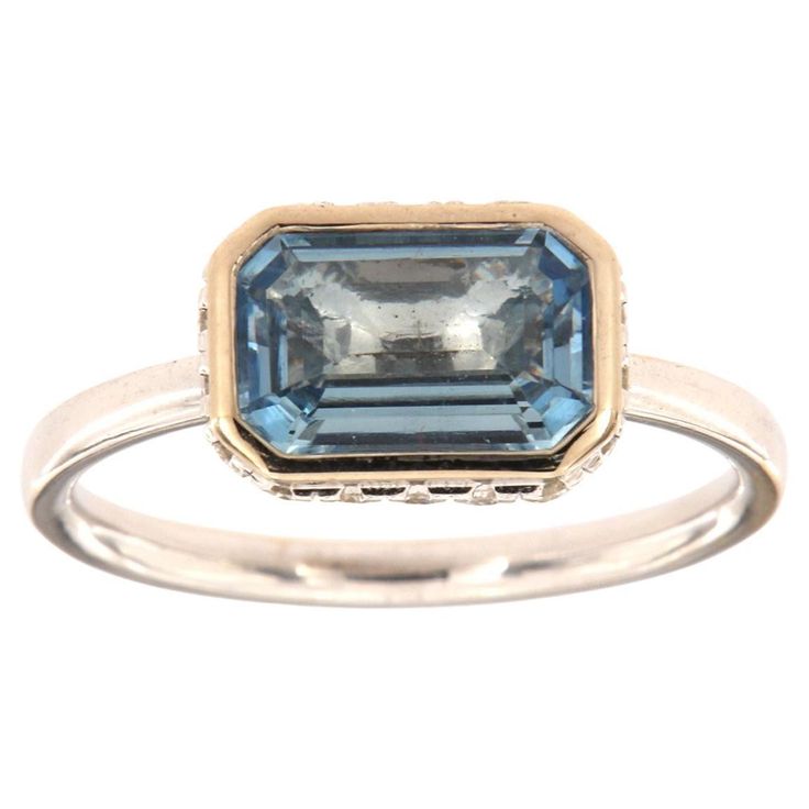 This 14k White gold delicate ring features a 1.23 Carat Blue Aquamarine emerald cut bezel set East-West style. Sixteen (16)Brilliant round diamonds are micro-prong set in a hidden halo on the crown to create the sparkle look every woman is looking to have. The diamond weight is 0.23 Carat, The band is 2 mm wide, and the ring size is 6.5 and resizable per request. Formal Radiant Cut Rings With Bezel Setting, Formal Bezel-set Baguette-cut Emerald Ring, Formal Baguette Cut Emerald Ring With Bezel Setting, Elegant Yellow Gold Emerald-cut Topaz Ring, Elegant Emerald Cut Yellow Gold Topaz Ring, Elegant Yellow Gold Emerald Cut Topaz Ring, Emerald-cut Topaz Ring In 14k White Gold, Emerald Cut Topaz Ring In 14k White Gold, Blue Emerald Cut Ring With Bezel Setting