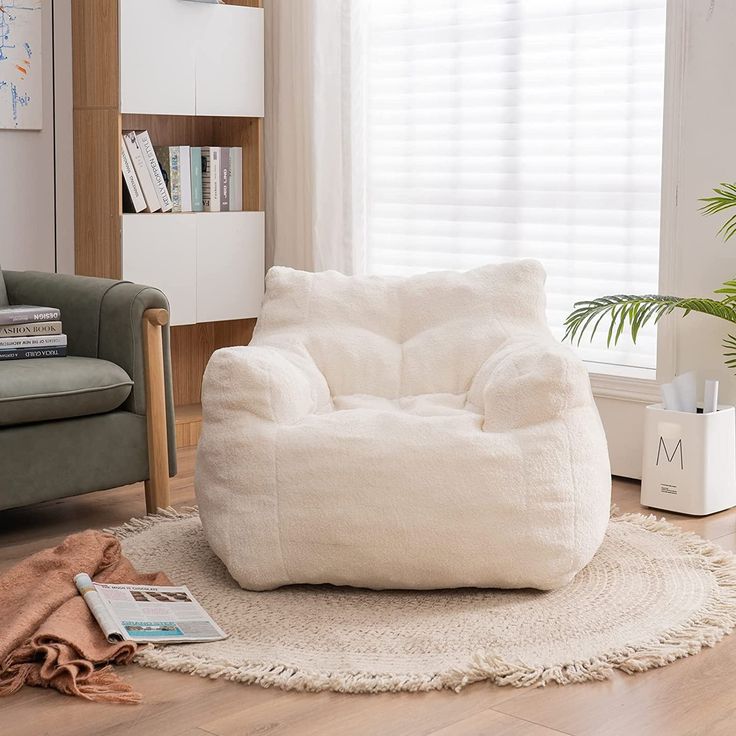 a white bean bag chair sitting on top of a rug in front of a window