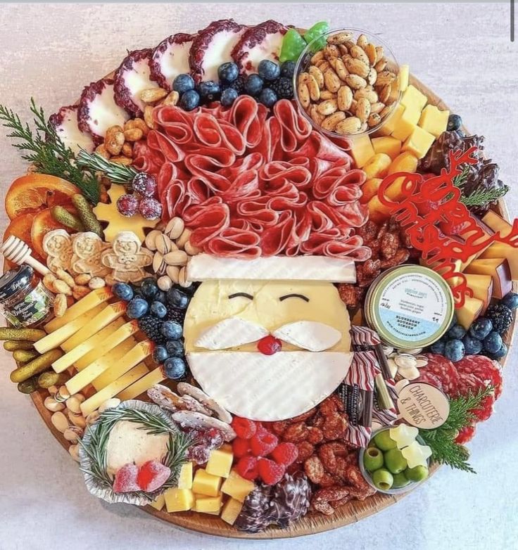 a platter filled with meats, cheeses, and other foods that are arranged in the shape of santa claus