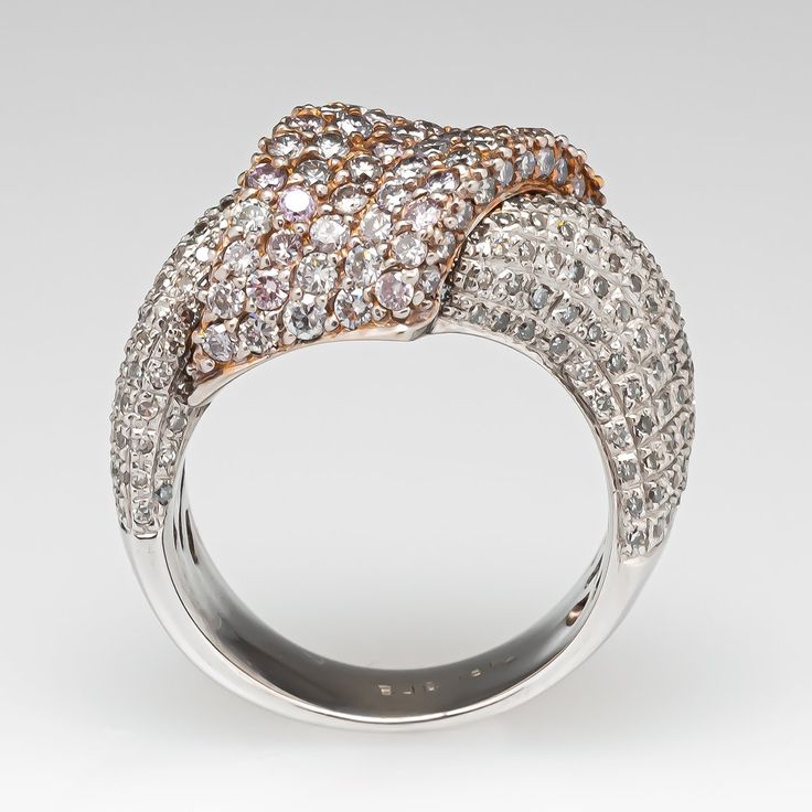 This lovely ring features a ribbon design by Samuel Benham and is accented with eighty-eight (88), bead set, round brilliant cut pink colored diamonds and two hundred three (203), bead set, round single cut diamonds. The ring measures 15.0mm at the top, rises 7.3mm above the finger, tapering to 5.6mm wide and 1.4mm thick at the base of the shank. Trademarks: BJC The ring is currently size 6.25. Luxury Pink Sapphire Ring With Brilliant Cut, Brilliant Cut Pink Sapphire Diamond Ring In White Gold, Luxury Pink Sapphire Ring With Pave Setting, Fine Jewelry Pink Sapphire Multi-stone Diamond Ring, Diamond White Multi-stone Ring For Formal Occasions, Fine Jewelry Pink Sapphire Diamond Ring With Multi-stones, Elegant Multi-stone Pink Sapphire Diamond Ring, Luxury Pink Rings With Pave Setting, Luxury Pink Diamond Ring With Brilliant Cut